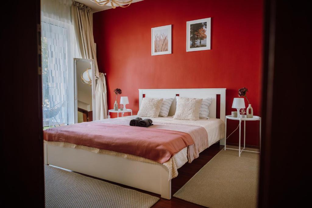 a red bedroom with a bed with a red wall at Glow Central Apartment Eminescu in Târgu-Mureş