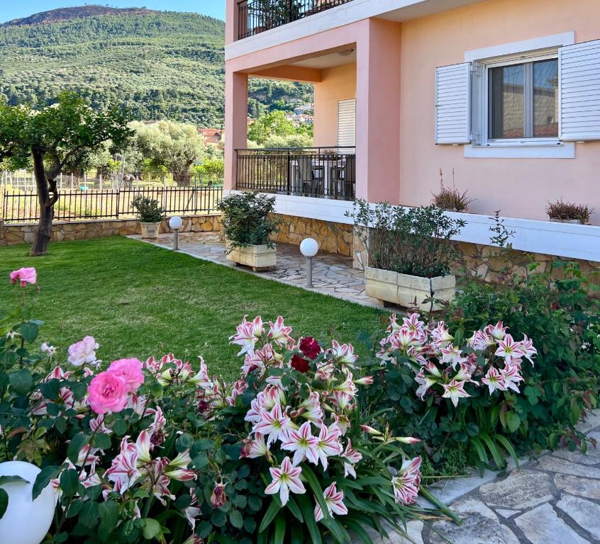 a garden with pink flowers in front of a house at Akratas Brothers House in Akrata
