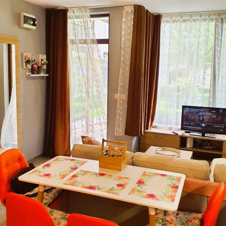 a living room with a table and a couch at Студио Стайл - Соренто Соле Маре in Sveti Vlas