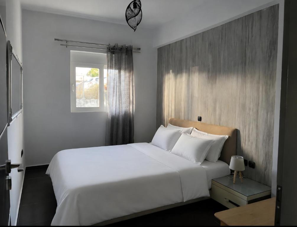 ein Schlafzimmer mit einem großen weißen Bett und einem Fenster in der Unterkunft Valla Studio in Rhodos (Stadt)