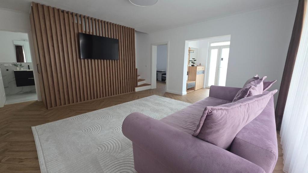 a living room with a purple couch and a tv at MarioLia Comfort Residence in Oradea