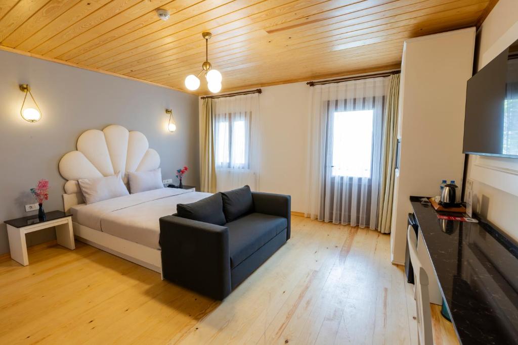 a bedroom with a bed and a chair and a television at Mai İnci Pera Hotel İstanbul in Istanbul