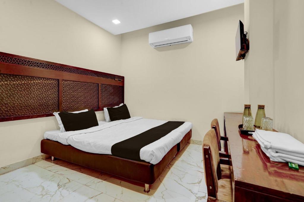 a bedroom with a large bed with a wooden headboard at HOTEL O INNORA in Raipur