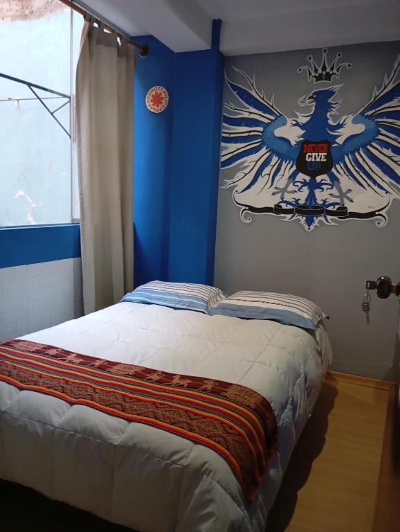 a bedroom with a bed with a painting on the wall at APARTAMENTO Acogedor cerca del aeropuerto Cusco in Cusco