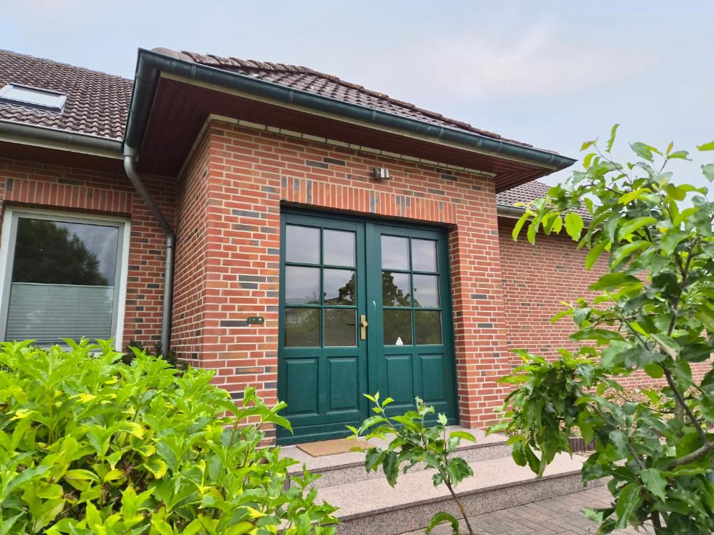 a brick house with a green door at Wohnung Ton Strand in Fehmarn