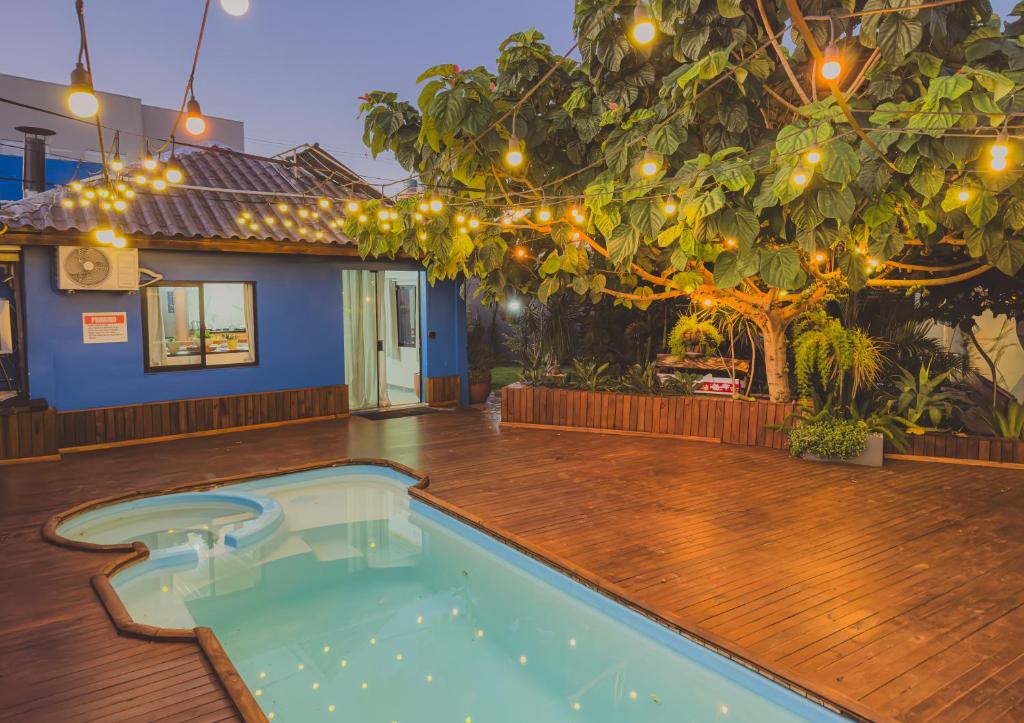 a swimming pool on a wooden deck with a tree and lights at Cabana com Hidro, Lareira e Piscina Privativa in Chapecó