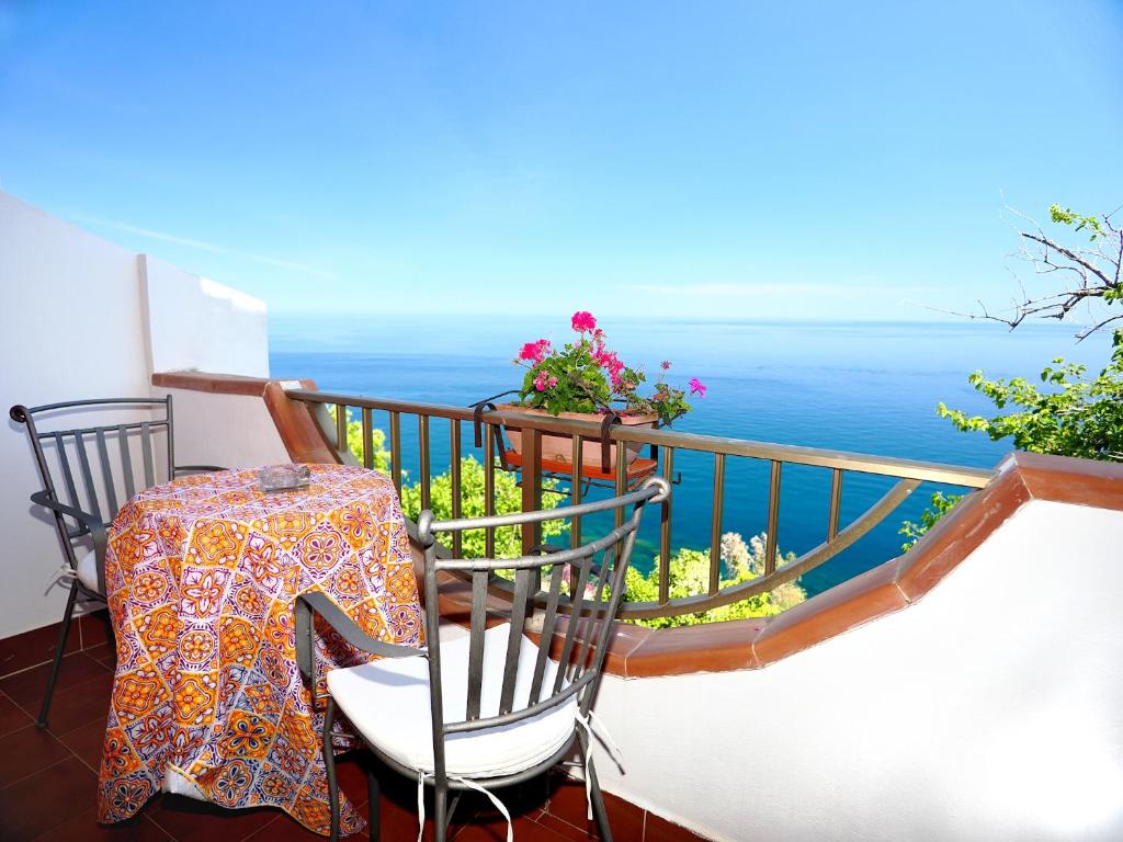 a balcony with a table and chairs and the ocean at Camere Santa Margherita in Santa Margherita-Sant'Alessio Siculo