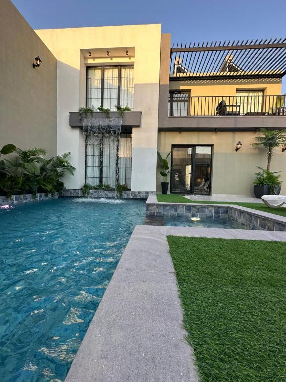 a house with a swimming pool next to a building at TRIO Chalet 1 in Sowayma