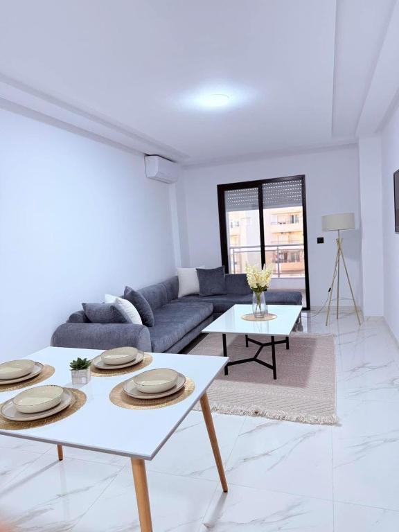 a living room with a couch and a table at Résidence jawhret el kram in El Aouina Station