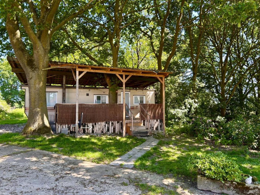 a house with a gazebo in the shade of trees at Hofquartier Greven in Greven