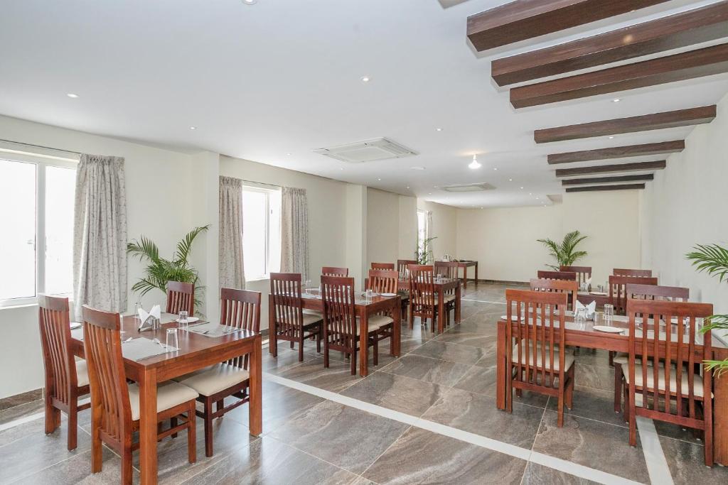 a dining room with wooden tables and chairs at Super Hotel O Ivy Dew Drops in Bangalore
