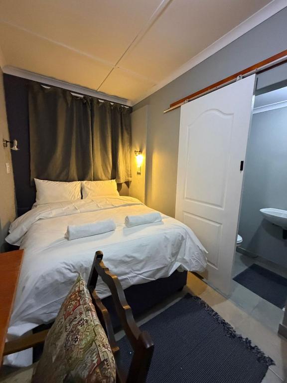 a bedroom with a bed with a window and a chair at Amani Nest in Arcadia