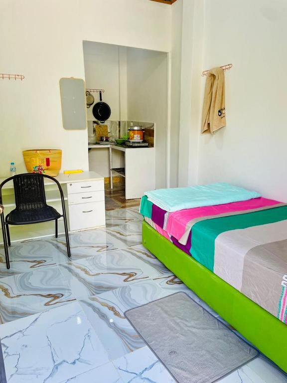 a bedroom with a bed and a chair on the floor at Sunmoon Apartment in Deli