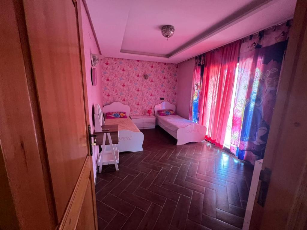 a small room with two beds and pink curtains at Villa ETAHIRI in Marrakesh
