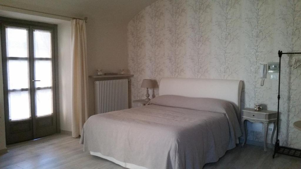 1 dormitorio con cama blanca y ventana en Novecento Charming Room, en Avigliana