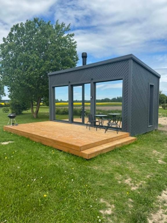 a tiny house with a deck and a table at EstBerg Tartu Glasshouse with Sauna in Tartu