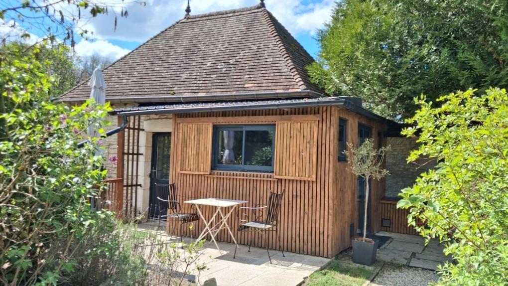 a small wooden cabin with a table in a yard at La Tour in Châtillon-sur-Seine