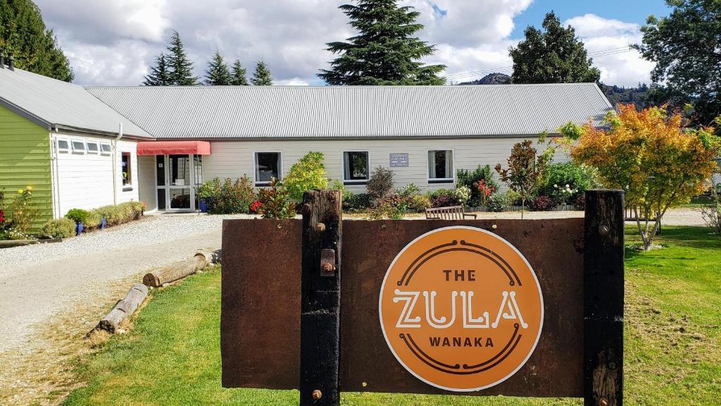 a house with a sign in front of it at Zula Lodge in Wanaka