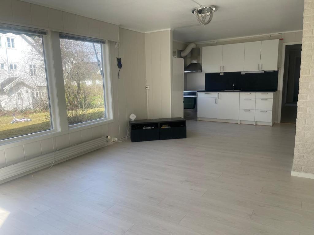 an empty room with a kitchen and a large window at Best place to live in Trondheim