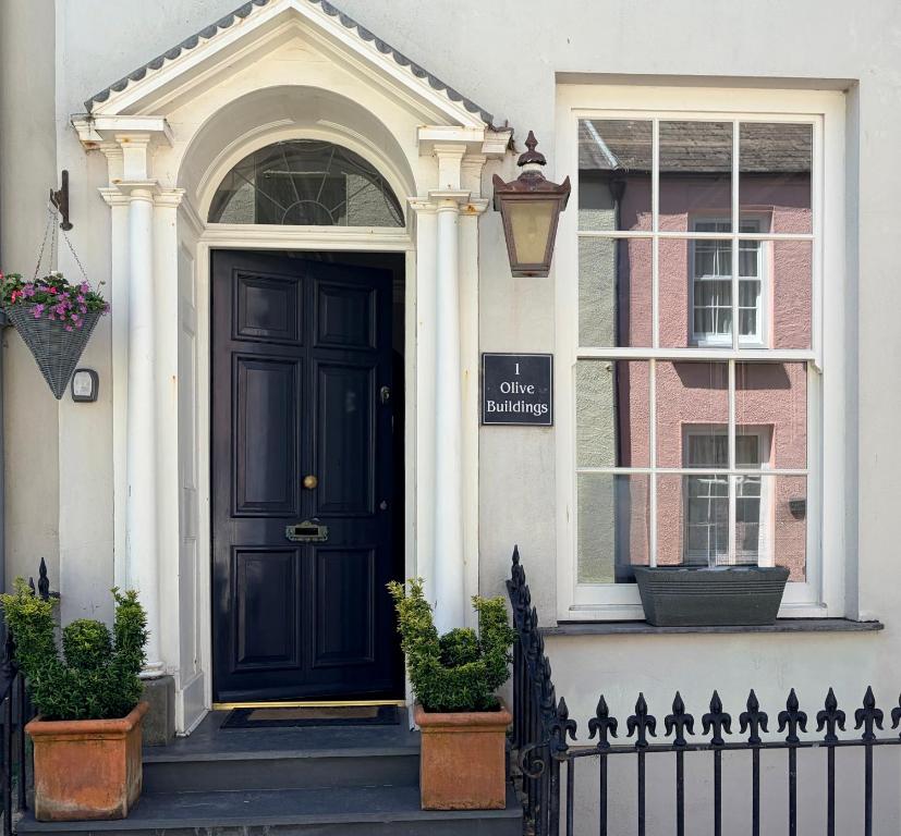 a black door on a white house with a window at Luxury Georgian Townhouse Tenby Sleeps 8 Parking Permit in Tenby