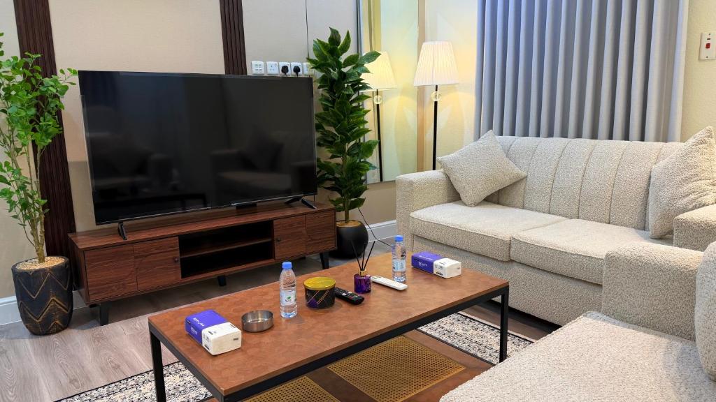 a living room with a couch and a television at الجوهره حائل in Hail