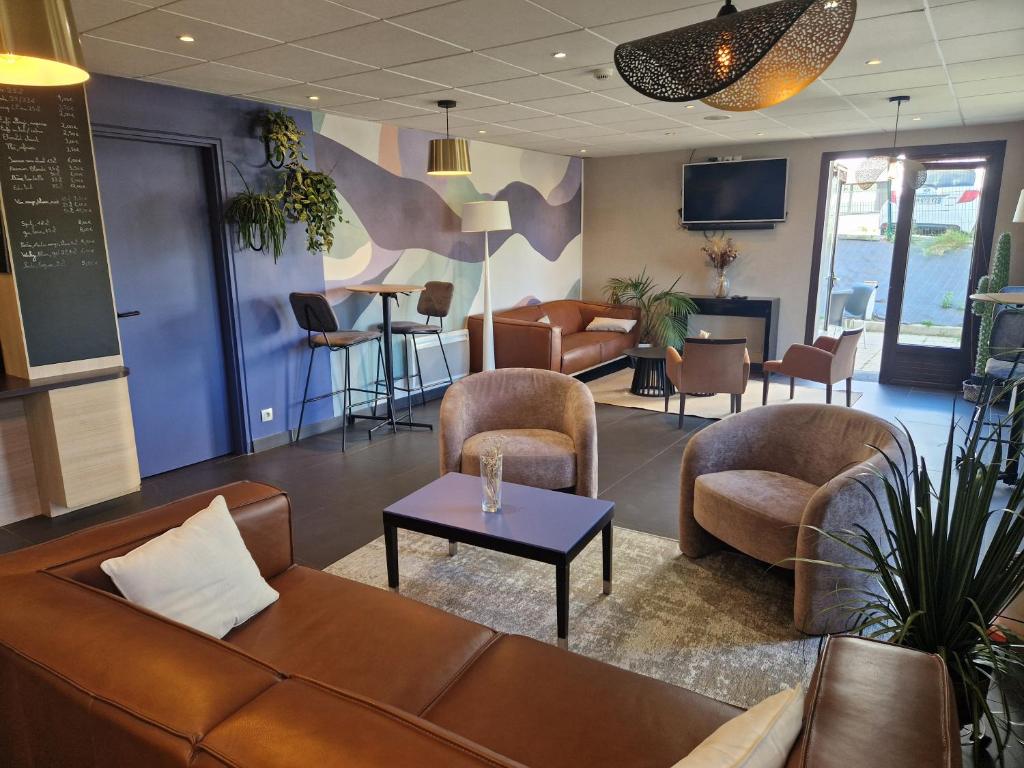 a waiting room with couches and chairs and a table at Kyriad Quimper Sud in Quimper