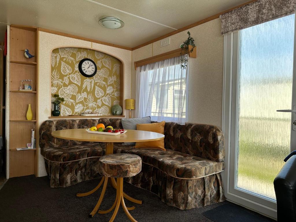 a living room with a couch and a table at Klara Happy Days in Trusthorpe