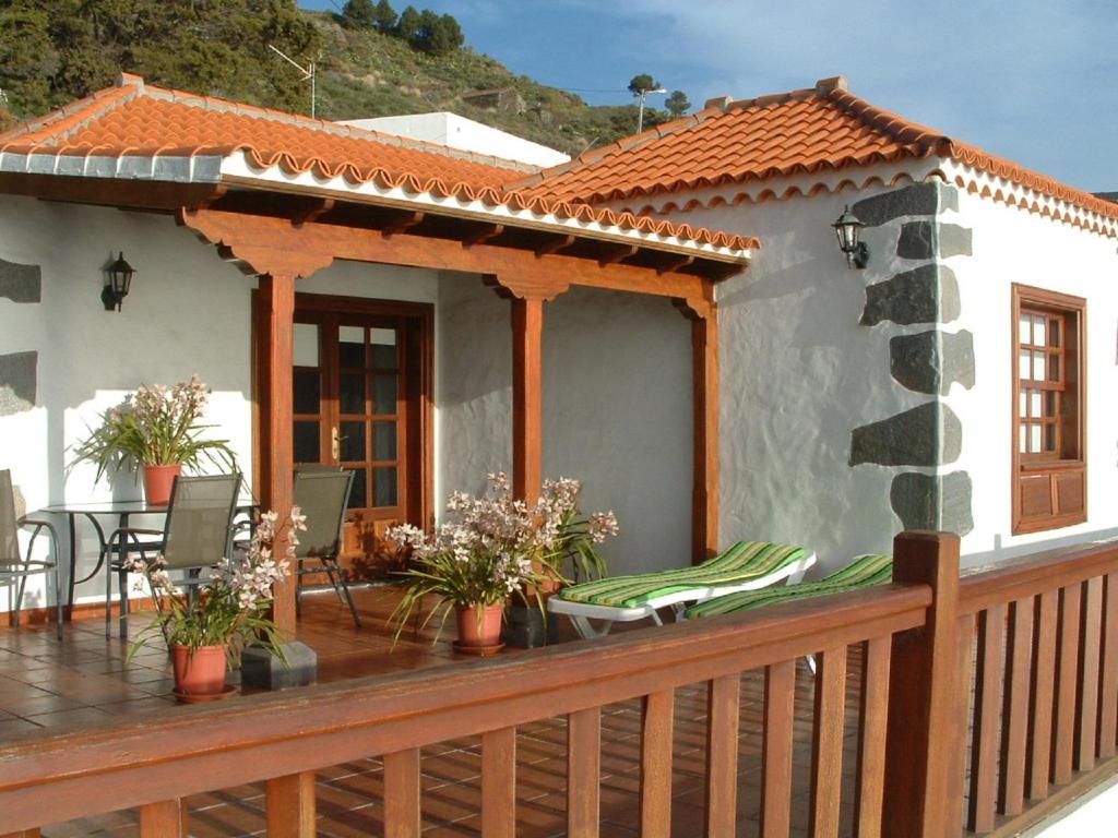 uma casa com um deque com uma mesa e cadeiras em Casa Los Viñedos A em Fuencaliente de la Palma