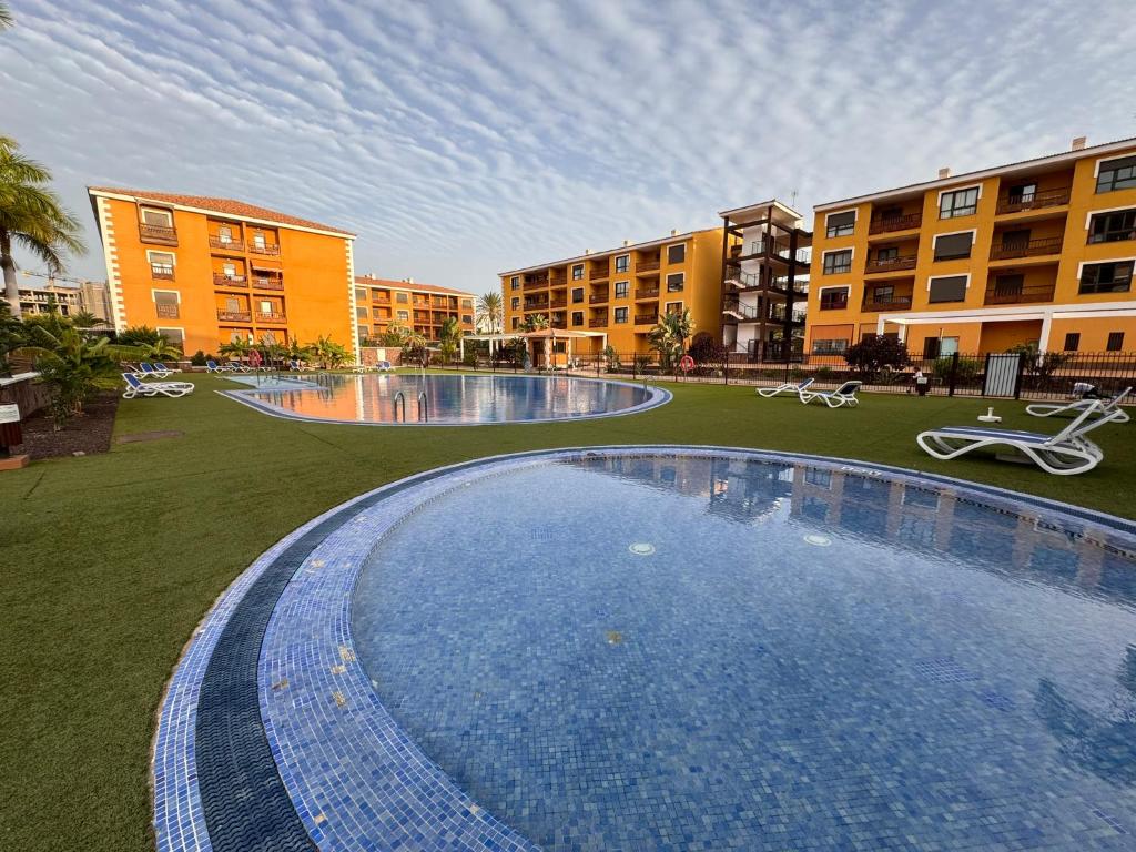 a large swimming pool in the middle of a building at Alquilaencanarias El Palm Mar in Palm-Mar