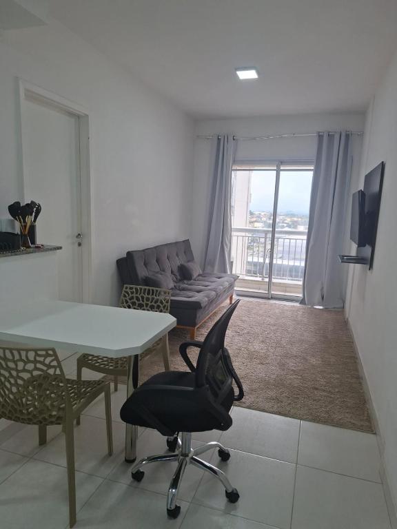 a living room with a couch and a table and chair at Flat Itaguai in Itaguaí
