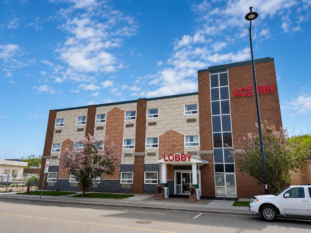 a red brick building with a large inn sign on it at Ace Inn in Fort McMurray