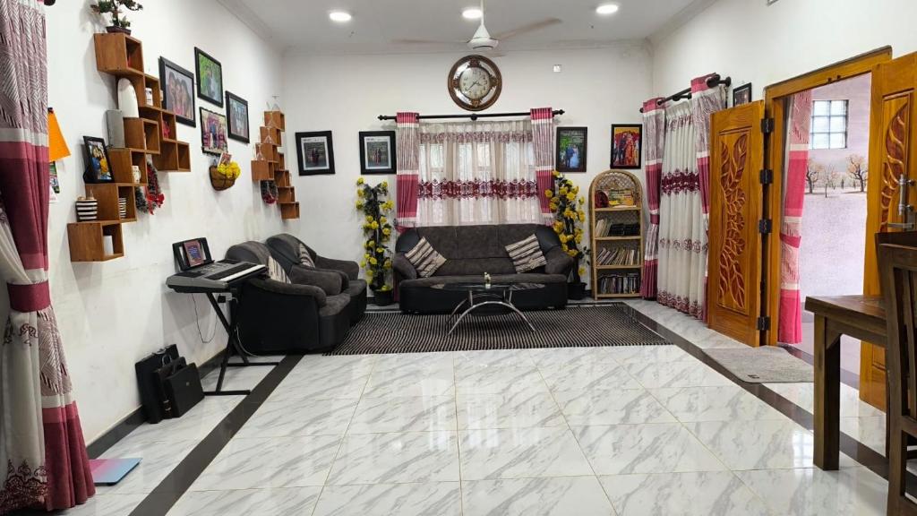 a living room with a couch and a chair at Apex inn in Manippai
