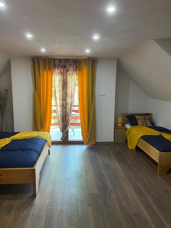 a bedroom with two beds and a large window at Plitvice Fairytale1 in Jezerce