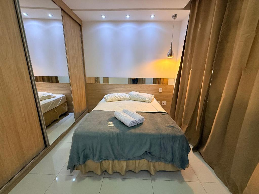 a bedroom with a bed with two towels on it at Apartamento 4 Quartos Completo UEMG Parque Expô in Divinópolis