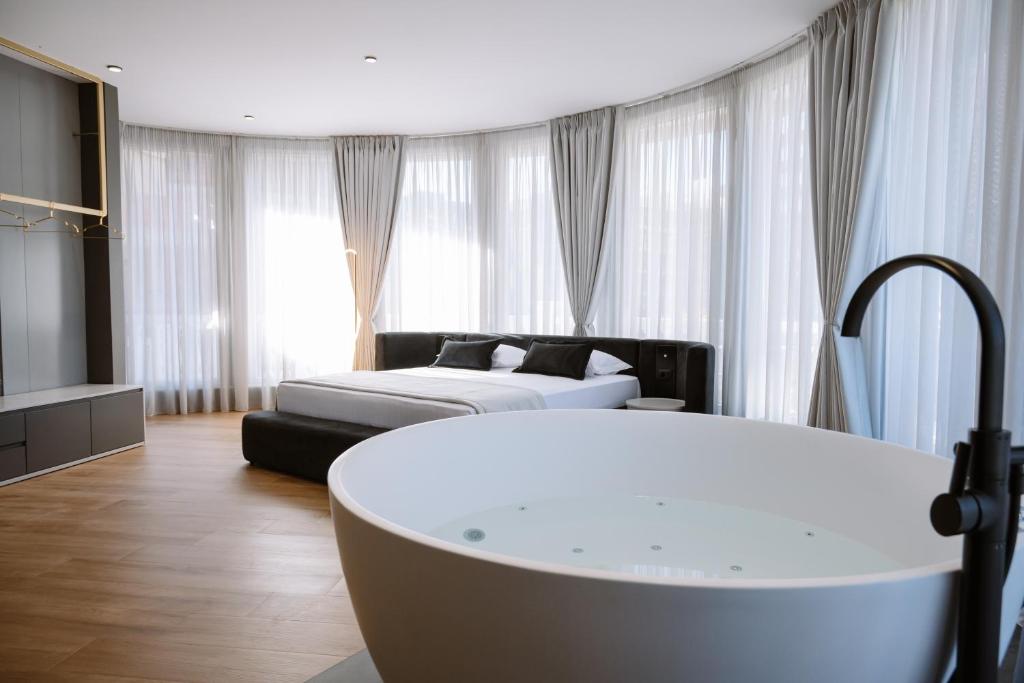 a living room with a couch and a white tub at Villa 100 Boutique Pogradec in Pogradec