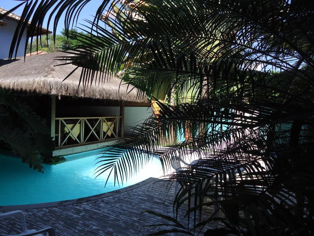 een uitzicht op een resort met een zwembad en een strohut bij Pousada La Cigale in Paraty