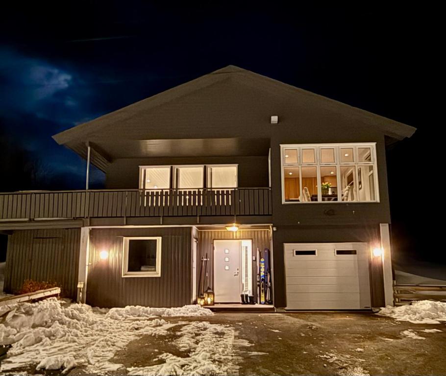 a house at night with snow in front of it at Villa Storvoll - Fjord & Mountain View in Lyngen