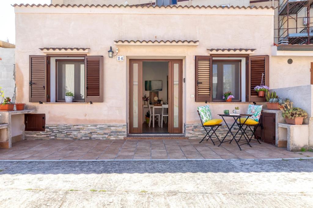 a patio with chairs and a table in front of a house at Deiana's House in Alghero