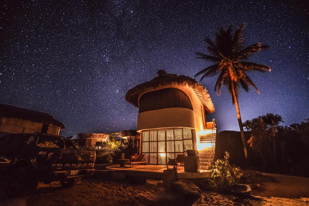 a house with a palm tree and a starry sky at Casa Sal by Tasman in Puerto Escondido