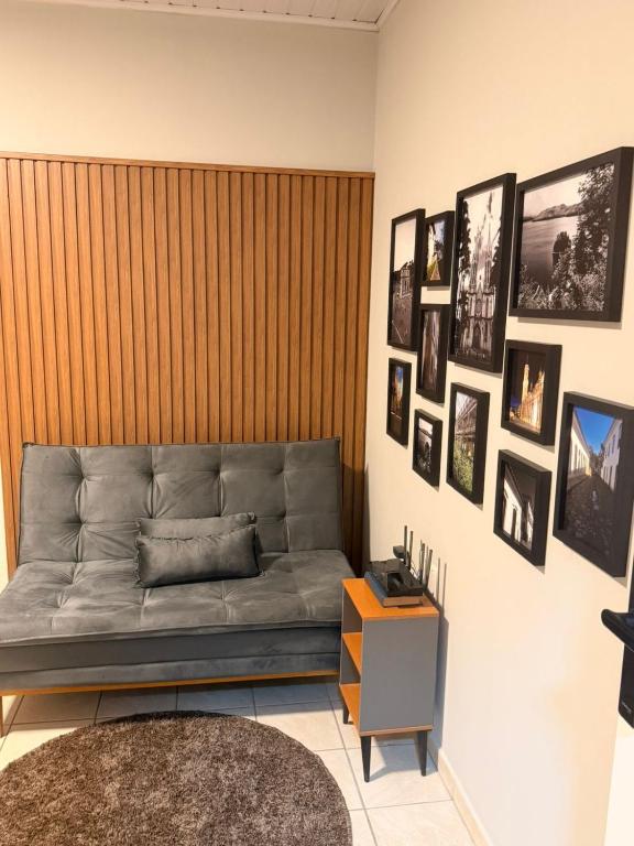 a living room with a couch and pictures on the wall at Apart Centro 06 in Tubarão