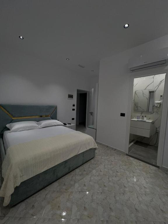 a white bedroom with a bed and a sink at StayVibe in Krujë