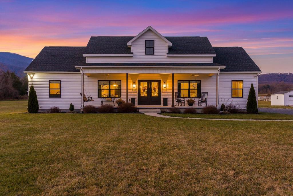 a white house with a sunset in the background at Afton Awaits in Afton