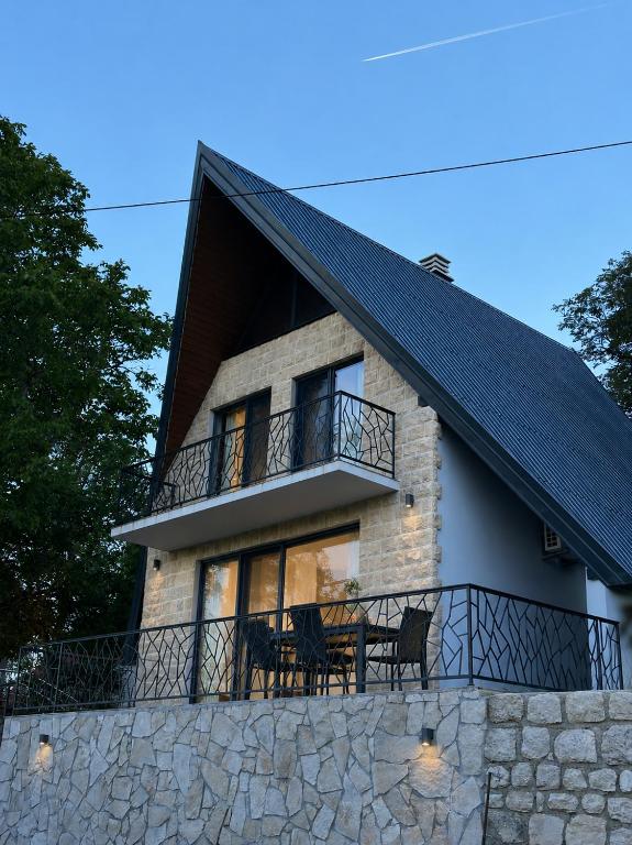 a house with a table and chairs on a balcony at Villa Vasilije in Šavnik