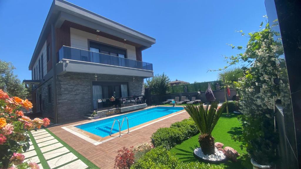a house with a swimming pool in a yard at Melisa Luxury Villa in Dosemealti