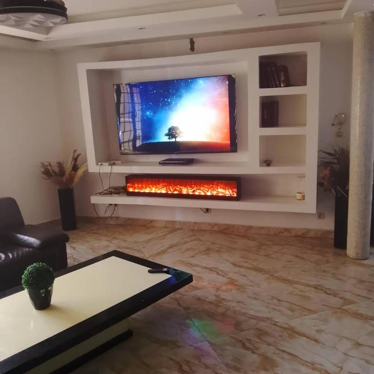 a living room with a flat screen tv on a wall at Mouhidiny Log Appart prestige in Dakan