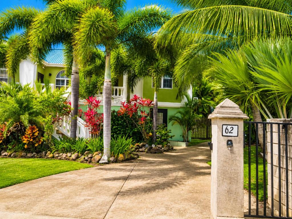 a house with a gate and a sign in front of a driveway at Eden Apartments in Basseterre