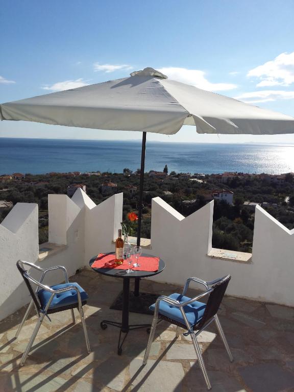 a table and chairs with an umbrella on a roof at Kastro Villas in Marathokampos