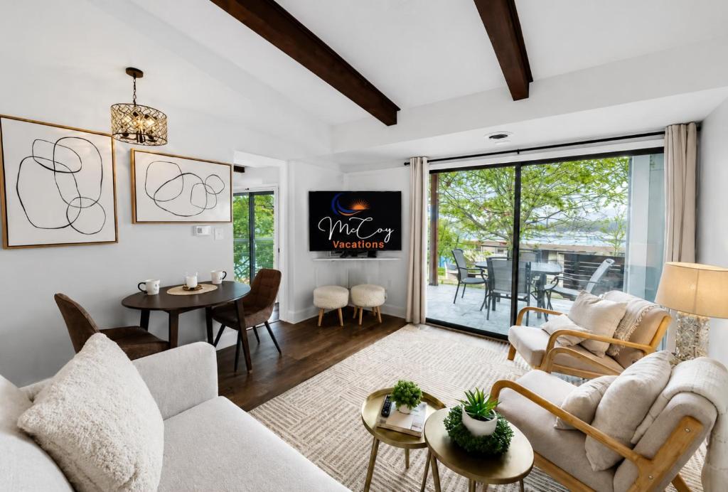 a living room with white furniture and a dining room at Lake it Easy at Kimberling Crossing in Kimberling City