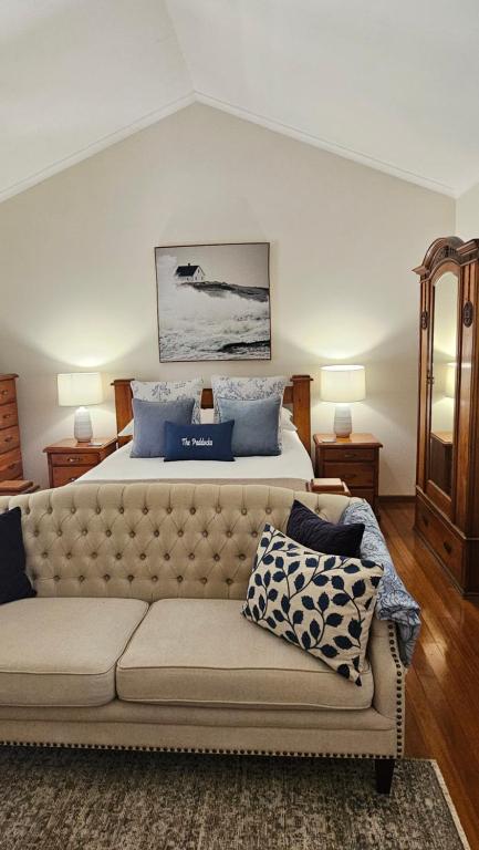 a bedroom with a large bed and a couch at The Paddocks in Maleny