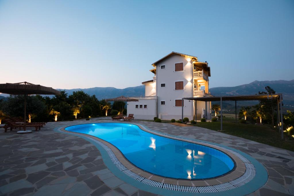 a villa with a swimming pool in front of a building at Panorama Hills Entire Villa in Gjirokastër